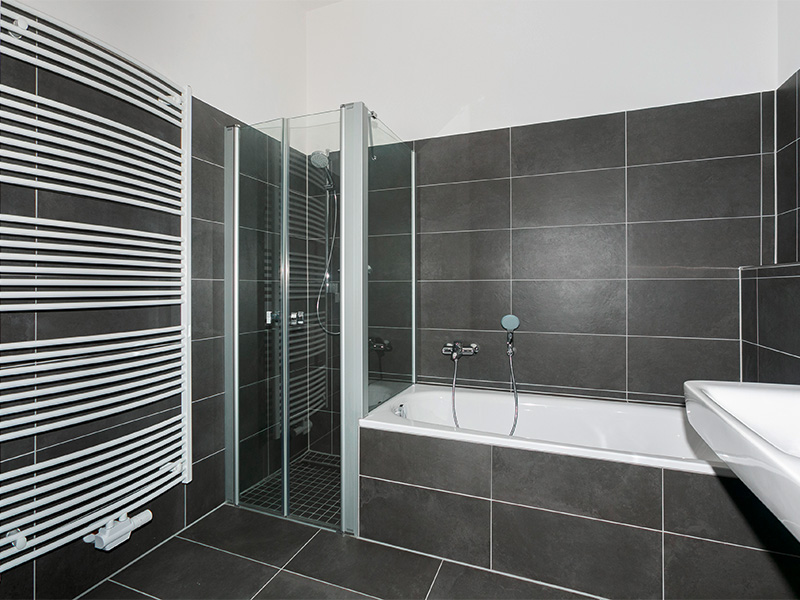 Modernes Badezimmer nach erfolgreicher Badsanierung in Iserlohn mit stilvoller Duschtrennwand und eleganter Einrichtung.