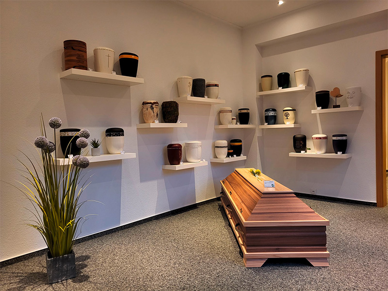 Ausstellungsraum von Bestattungen Schnabel in Iserlohn mit Urnen, Särgen und würdevoller Präsentation.