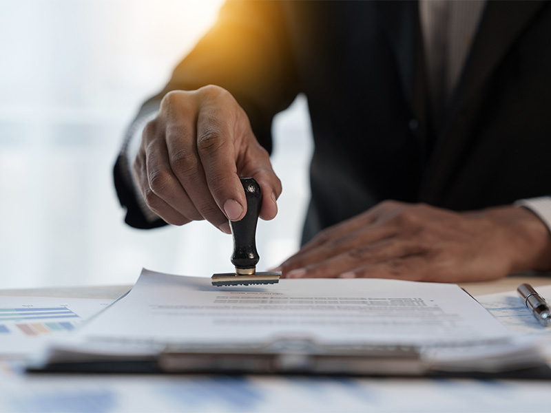 Geschäftsmann stempelt Vertrag – symbolisiert notarielle Beurkundung eines Kaufvertrags in Iserlohn.