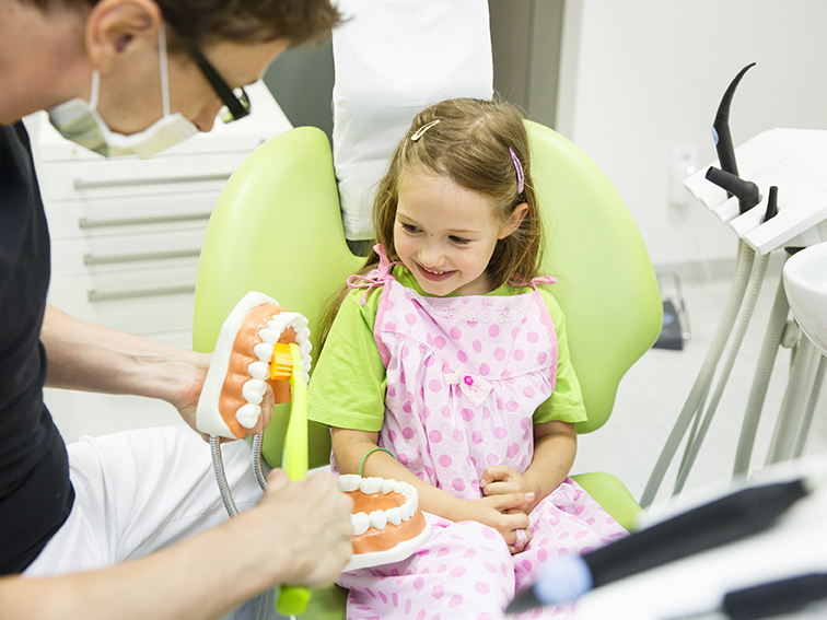 Kinderzahnarzt in Iserlohn zeigt einem Kleinkind das richtige Zähneputzen