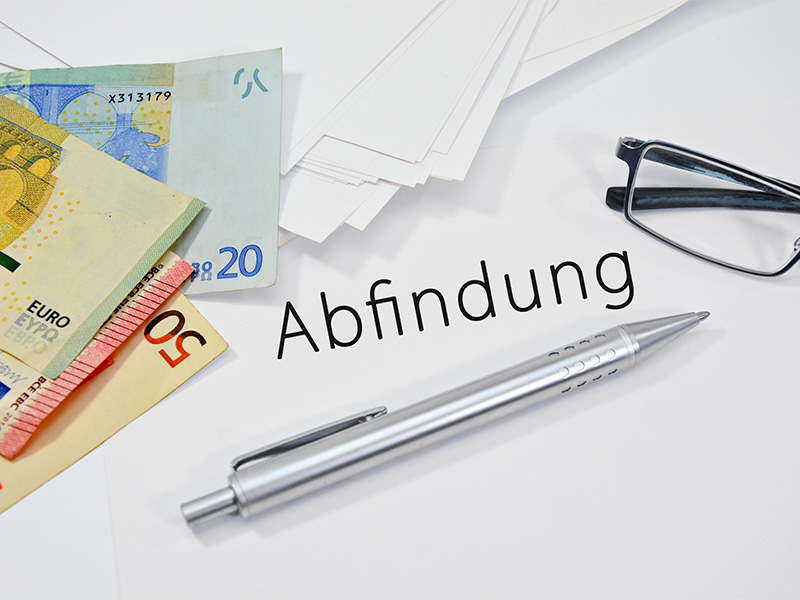Geschäftsmann erhält Dokumente zur Abfindung, symbolisiert rechtliche Ansprüche und finanzielle Ausgleichszahlung nach Kündigung.
